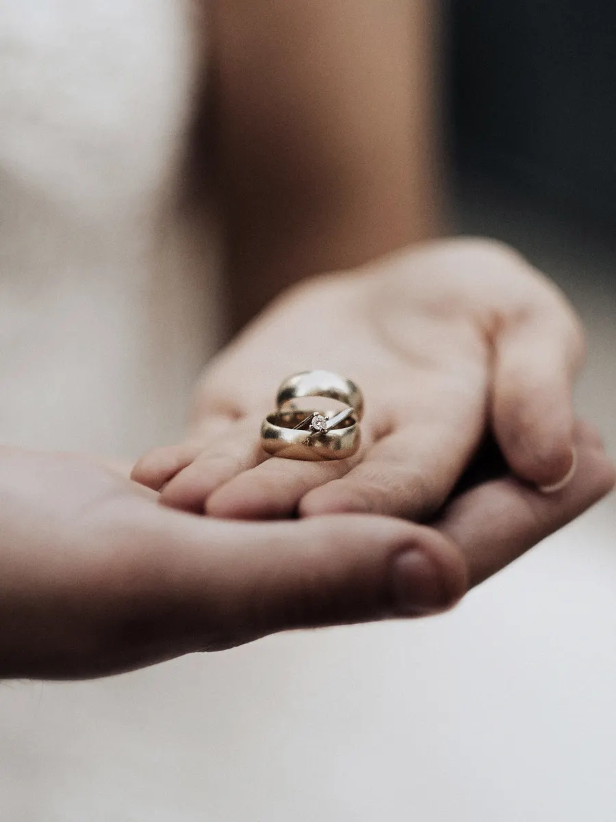 Bridal detail with wedding rings held in hand