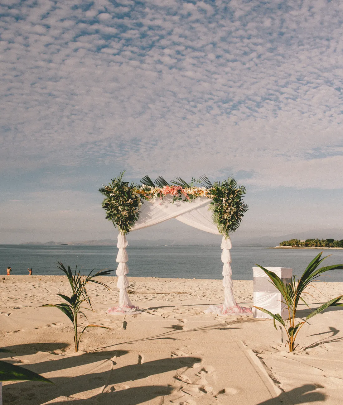Wedding arch on a sandy beach framed by the ocean and sky